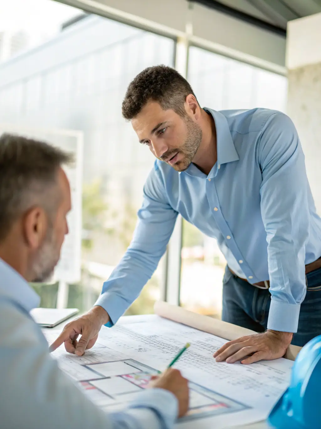 Close-up shot of a consultant's hands pointing at a detailed architectural diagram of an embedded system during an initial client meeting, emphasizing collaboration and understanding project requirements.